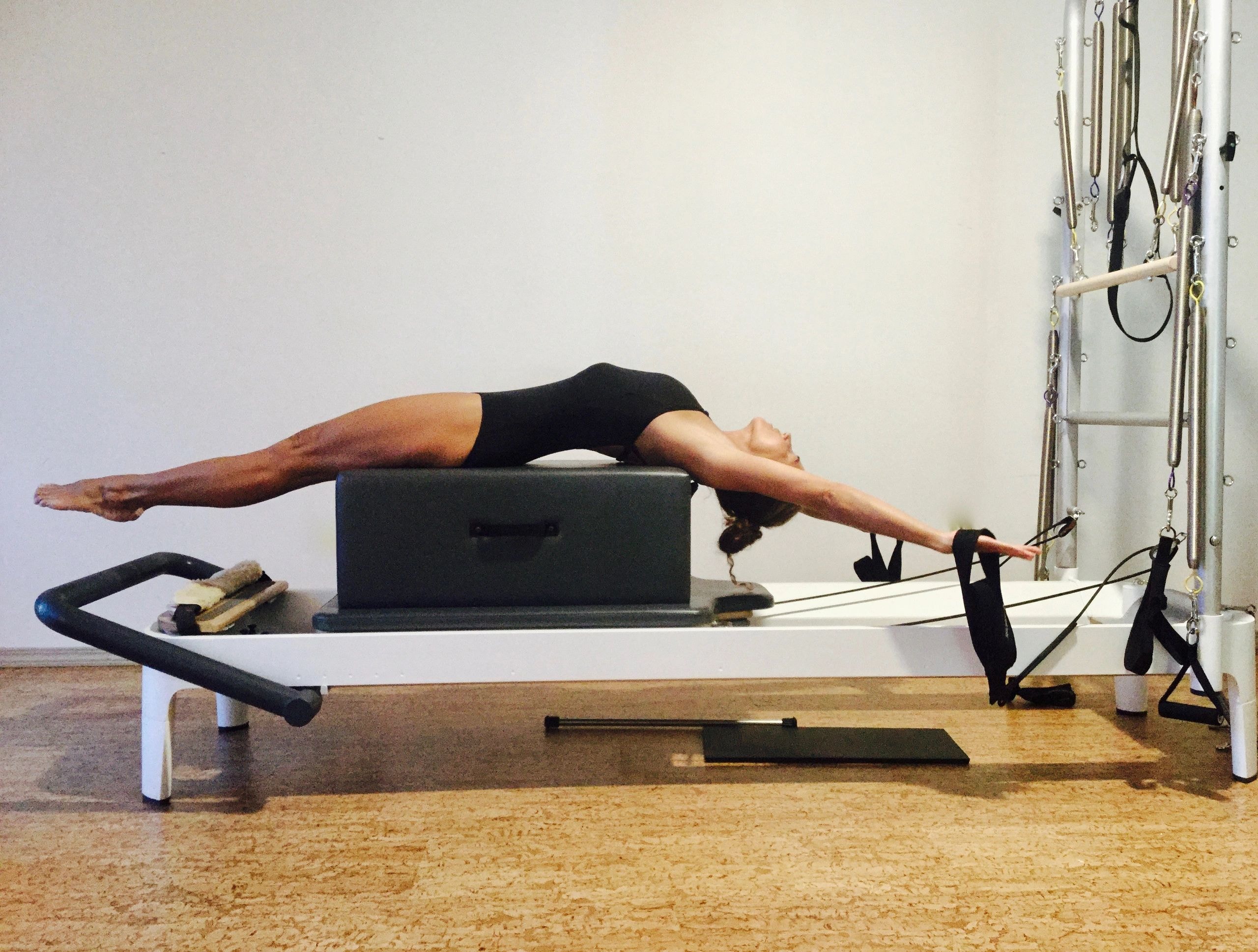 Person performing horizontal plank on Pilates reformer